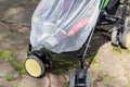 Child in stroller covered with protective net during walk. Baby carriage with anti-mosquito white cover. Midge protection for