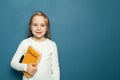Child student girl with Deutsch language book on the background of blue chalkboard Royalty Free Stock Photo