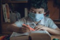 Child studying a book in the 2020 classes in the middle of the covid-19 Royalty Free Stock Photo
