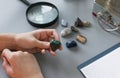 child studying collection of semiprecious stones on gray desk