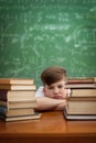 Child studying on desk looking bored and under stress with a tir Royalty Free Stock Photo