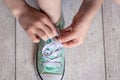 Child successfully ties shoes, close up on feet. Royalty Free Stock Photo