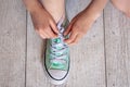 Child successfully ties shoes, close up on feet. Royalty Free Stock Photo