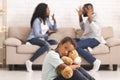 Child suffering from parents quarrels, sitting and cuddling teddy bear Royalty Free Stock Photo