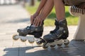 Child in the summer on the street wears gray roller skates close-up