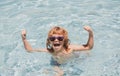 Child in summer swimming pool. Excited cute little boy in sunglasses in pool in sunny day. Royalty Free Stock Photo