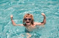 Child in summer swimming pool. Excited cute little boy in sunglasses in pool in sunny day. Royalty Free Stock Photo