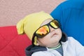 A child in sunglasses protects eyesight from the sun. lies on the pillows. relax Royalty Free Stock Photo