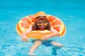 Child in sunglasses and summer hat floating in pool. Child having fun in summertime. Summer holidays and vacation with Royalty Free Stock Photo