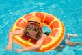 Child in sunglasses and summer hat floating in pool. Little child boy swimming in summer pool. Cute kid relaxing and Royalty Free Stock Photo