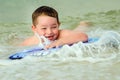 Child surfing on bodyboard at beach Royalty Free Stock Photo