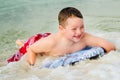 Child surfing on bodyboard at beach Royalty Free Stock Photo