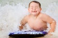 Child surfing on bodyboard at beach