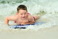 Child surfing on bodyboard at beach