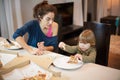 Child surprise face with a pizza broken piece with mother