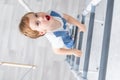 A child on the Swedish wall plays sports at home, a boy climbs a ladder with a rope, the concept of sports and health