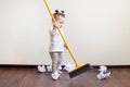Child sweeps broom with paper bins in the apartment, household chores Royalty Free Stock Photo