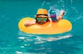 Child in swim pool swimming on inflatable ring. Kid swim with orange float. Water toy, healthy outdoor sport activity Royalty Free Stock Photo