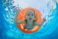 Child swimming on orange inflatable tube in pool Royalty Free Stock Photo