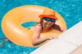 Child in swimming pool on inflatable ring. Kid swim with orange float. Kids beach fun. Royalty Free Stock Photo