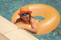 Child in swimming pool on inflatable ring. Kid swim with orange float. Kids beach fun. Royalty Free Stock Photo