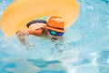 Child in swimming pool on inflatable ring. Kid swim with orange float. Kids beach fun. Royalty Free Stock Photo