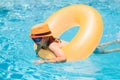 Child in swimming pool on inflatable ring. Kid swim with orange float. Kids beach fun. Royalty Free Stock Photo