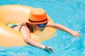 Child in swimming pool on inflatable ring. Kid swim with orange float. Kids beach fun. Royalty Free Stock Photo