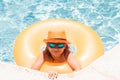 Child in swimming pool on inflatable ring. Kid swim with orange float. Water toy, healthy outdoor sport activity for Royalty Free Stock Photo