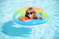 Child in swimming pool on inflatable ring. Little boy learning to swim with float. Water toy for toddler. Healthy Royalty Free Stock Photo