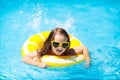 Child in swimming pool on ring toy. Kids swim Royalty Free Stock Photo