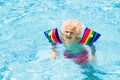 Child in swimming pool. Kid with float armbands Royalty Free Stock Photo