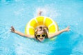 Child in swimming pool on ring toy. Kids swim Royalty Free Stock Photo