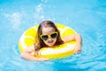 Child in swimming pool on ring toy. Kids swim Royalty Free Stock Photo