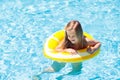 Child in swimming pool on ring toy. Kids swim Royalty Free Stock Photo