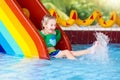 Child on swimming pool slide. Kids swim. Water fun Royalty Free Stock Photo