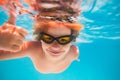 Child in swimming pool underwater with thumbs up. Underwater kid swim in pool. Child boy swimming and diving underwater Royalty Free Stock Photo