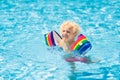 Child in swimming pool. Kid with float armbands Royalty Free Stock Photo