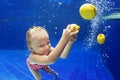 Child swimming underwater in blue pool for yellow lemon Royalty Free Stock Photo