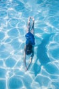 Child swimming underwater in an outdoor pool Royalty Free Stock Photo