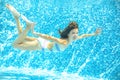 Child swims in pool underwater, happy active girl dives and has fun under water, kid sport Royalty Free Stock Photo