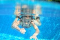 Child swims in pool underwater, happy active girl has fun under water, kid sport Royalty Free Stock Photo