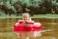 a child swims in the river in an inflatable circle Royalty Free Stock Photo