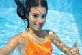 Child swims in swimming pool underwater, happy active teenager girl dives and has fun under water, kid fitness and sport Royalty Free Stock Photo