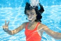 Child swims in swimming pool underwater, happy active teenager girl dives and has fun under water, kid fitness and sport Royalty Free Stock Photo