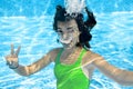 Child swims in swimming pool underwater, happy active teenager girl dives and has fun under water, kid fitness and sport