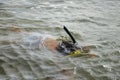 A child swims under water in a mask and a snorkel for the driver Royalty Free Stock Photo