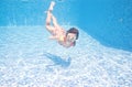 Child swims underwater in swimming pool, active little girl dives and has fun under water, kid fitness and sport Royalty Free Stock Photo