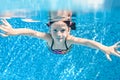 Child swims underwater in swimming pool, active little girl dives and has fun under water, kid fitness and sport Royalty Free Stock Photo