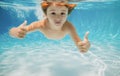 Child swims underwater in swimming pool, happy active boy dives and has fun under water, kids watersport. Children play Royalty Free Stock Photo